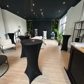 Réception élégante : tables hautes à housse noire dans un showroom moderne