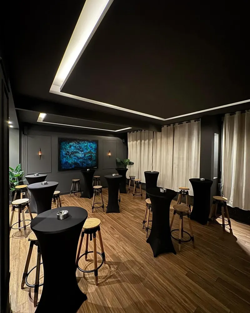Mariage extérieur : tables hautes à housse noire dans un espace lounge en soirée